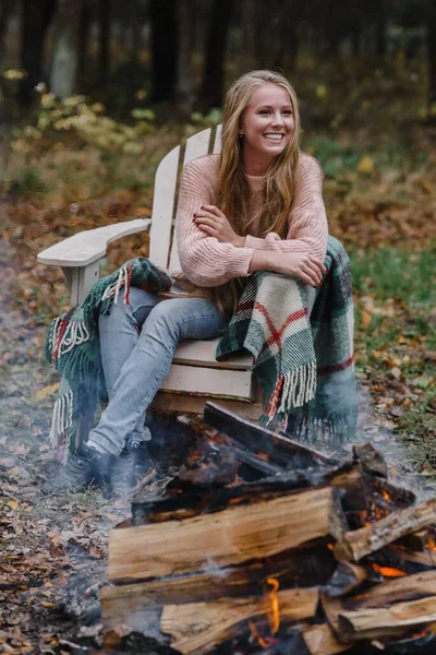 Jonge vrouw zitten bij het vuur in gekleurde warm ijs opwarmen vuur warmte lang haar — Stockfoto