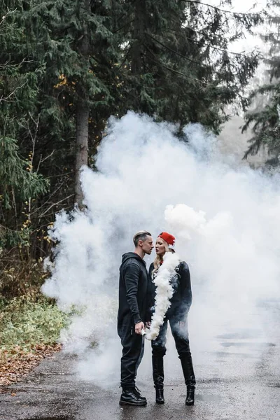 霧の中でキスしてるカップル。恋人優しさパスフォレストロマンスに白い煙蒸気色 — ストック写真