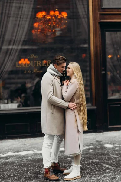 Amor pareja amor abrigo beige gris blanco ramo de flores ternura sentimientos caminar abrazo fecha — Foto de Stock