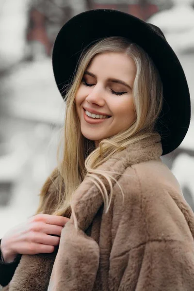 Mosolygó fiatal nő kalap kabát kívül virágok csokor sárga öröm ajándék szőke modell — Stock Fotó