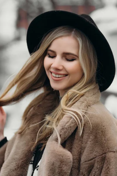 Usmívající se mladá žena klobouk kabát mimo květiny kytice žlutá radost dárek blondýny model — Stock fotografie