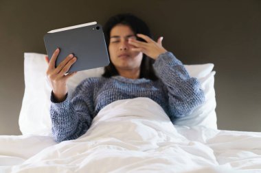 Geceleri dijital tablete uzun süre baktıktan sonra gözlerin yorgunluğu.