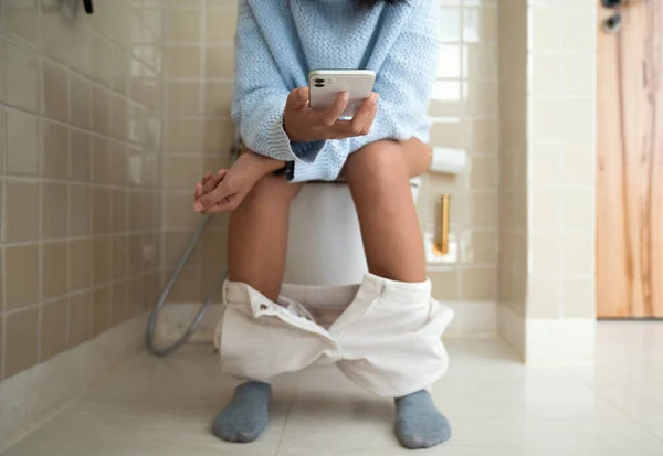 Vrouw Met Behulp Van Telefoon Tijdens Het Gebruik Van Badkamer — Stockfoto