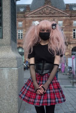 Strasbourg - Fransa - 2 Ekim 2021 - Sokakta pembe peruklu liseli kız kostümü giyen seksi kız portresi