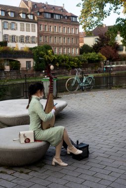 Strasbourg - Fransa - 23 Ekim 2021 - Sokakta geleneksel Çin keman çalan Asyalı kadın portresi