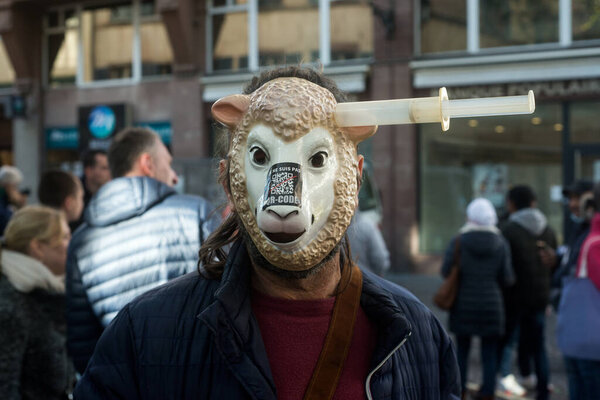 Strasbourg - France - 23 October 2021 - portrait of man protesting against the sanitary pass with a  sheep mask and syringe on head