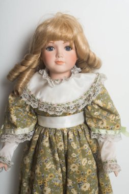 Beyaz arka planda yeşil bir ortaçağ elbisesi giyen klasik bebeklerin portresi