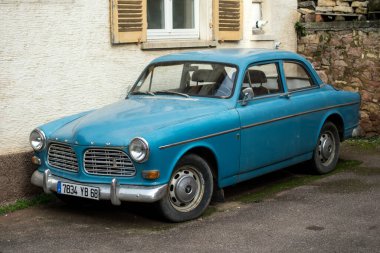 Eguisheim - Fransa - 22 Şubat 2021 - 1966 model mavi klasik Volvo Amazon arabasının ön görüntüsü Alsatian köyünün caddesinde park halinde