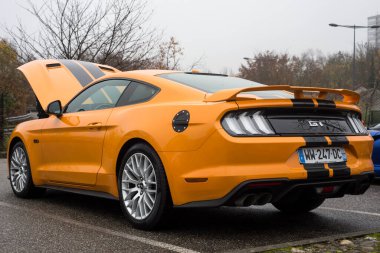 Mulhouse - Fransa - 14 Kasım 2021 - Turuncu Ford Mustang GT 5.0 'ın arka görüntüsü sokağa park edildi