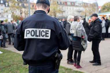 Colmar - Fransa - 13 Kasım 2021 - Sokakta dikilen Fransız polisinin arka plandaki portresi 