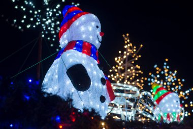 Yılbaşı dekoratif arka planında aydınlanmış kardan adamın yakın çekimi