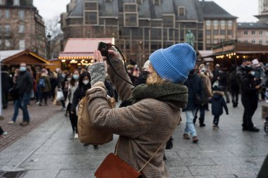 Strasbourg - Fransa - 11 Aralık 2021 - Sokakta noel pazarında fotoğraf çeken kadın portresi