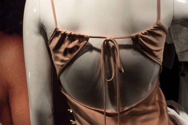 Moda mağazasının vitrininde seksi saten geceliğin yakın çekimi.