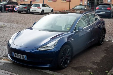 Colmar - Fransa - 2 Ocak 2021 - Caddeye park etmiş mavi Tesla 3 modelinin ön görüntüsü