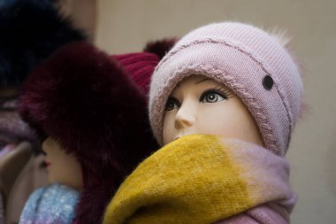 Caddedeki markette manken üzerinde yün şapkaların yakın çekimi.