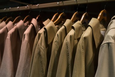 Bir moda mağazasındaki askılarda bej yelek koleksiyonu.