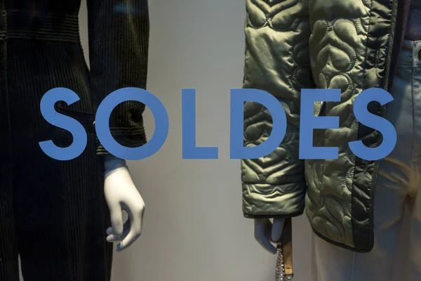 特写法国的折扣标志 Soldes 在法国时装店橱窗以冬季服装为背景的诱骗 销售至50 为英文 — 图库照片