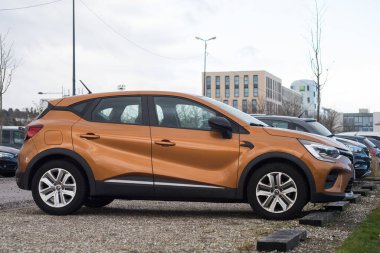 Mulhouse - Fransa - 17 Şubat 2022 - Turuncu Renault Captur SUV aracının caddeye park edilmiş profili