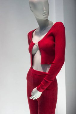 Moda mağazasının vitrininde kırmızı sütyen ve kırmızı taytlı kırmızı kazağın yakın çekimi.