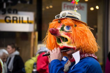 Basel - İsviçre - 9 Mart 2022 - Sokakta flüt çalan maskeli insanların portresi 