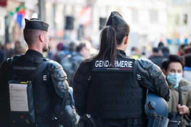 Strasbourg - Fransa - 19 Mart 2022 - Fransız jandarma polisinin sokakta yürürken arka plandaki portresi 