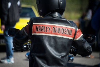 Mulhouse - Fransa - 10 Nisan 2022 - Harley Davidson marka deri ceket giyen motosikletlinin arka plandaki portresi