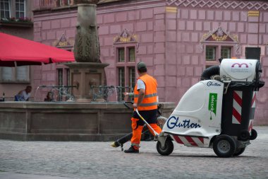 Mulhouse - Fransa - 12 Mayıs 2022 - Sokakları temizlemek için elektrikli süpürge kullanan belediye çalışanının portresi 