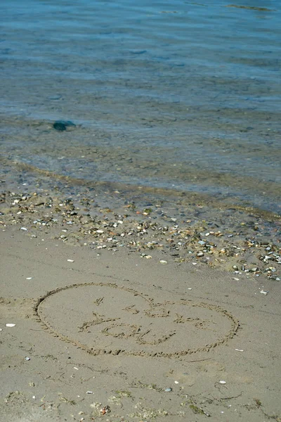 Closeup of heart and I love you text writing on the sand on the beach