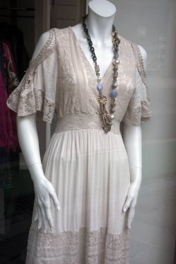Moda mağazasının vitrininde bej renkli boho tarzı elbisenin yakın çekimi. 