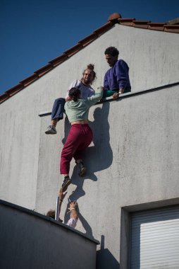 Mulhouse - France - 17 July 2022 - Group of street artists climbing at the building facade during the street scene festival