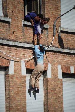 Mulhouse - Fransa - 17 Temmuz 2022 - Sokak Sahnesi Festivali sırasında sokak sanatçılarından oluşan bir grup binanın ön cephesine tırmandı