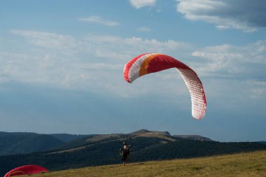 Le grand Ballon - France - 4 August  2022 - View of paraglider preparing her wing before the take off on blue sky background