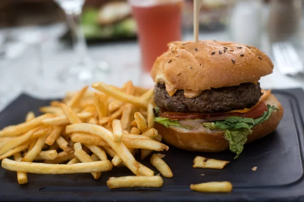 Closeup of burger and french fries at the restaurant terrace in the street