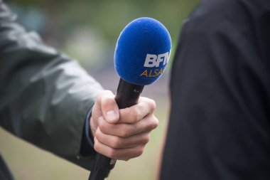 Strasbourg - Fransa - 17 Eylül 2022 - Sokaktaki gazetecinin elinde mavi bfmtv mikrofonunun kapanışı