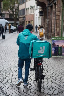 Strasbourg - Fransa - 17 Eylül 2022 - Deleveroo yeleği ve sırt çantalı bir bisikletli teslimatçının portresi