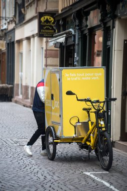 Strasbourg - Fransa - 17 Eylül 2022 - Sokakta duran postacı ve elektrikli bisiklet portresi