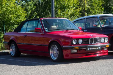 Mulhouse - Fransa - 11 Eylül 2022 - Caddeye park edilmiş kırmızı BMW M3 model arabanın ön görüntüsü 