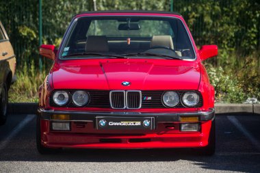 Mulhouse - Fransa - 11 Eylül 2022 - Caddeye park edilmiş kırmızı BMW M3 model arabanın ön görüntüsü 