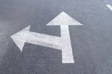 Düz ya da sola hareket yönü için asfalt yolda yol işaretleri.