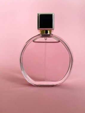 Pembe bir kutudan çıkan parfüm şişesi izole bir arka planda, maket ve kopyasal alan ile birlikte.