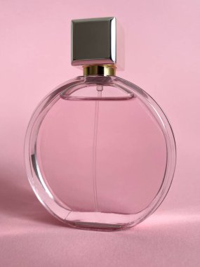 Pembe bir kutudan çıkan parfüm şişesi izole bir arka planda, maket ve kopyasal alan ile birlikte.