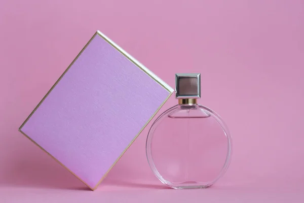 香水瓶从一个粉红色的盒子在一个孤立的背景与模型和版权空间 — 图库照片