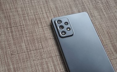 Siyah renkli cep telefonunun arka yüzü (akıllı telefon) desenli arkaplan üzerine