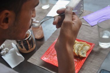 Güney Asyalı bir gencin fast food kafede Momo yediğini gördüm.