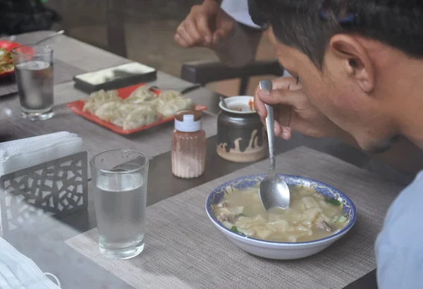 从玻璃窗望去 人们在室内咖啡馆里吃着提比坦食品 — 图库照片