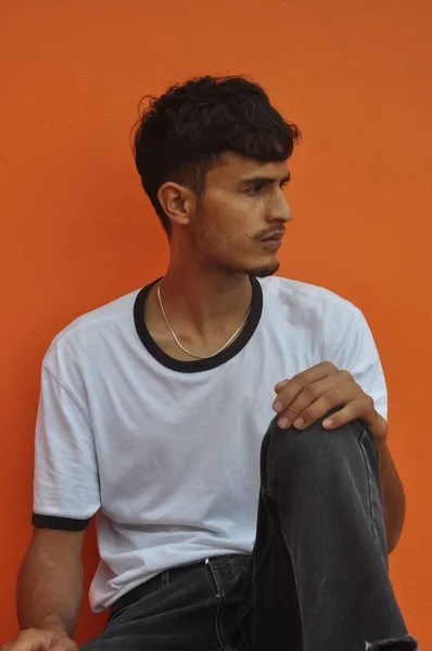 Good Looking Indian Young Guy Looking Sideways While Sitting Posing — стокове фото