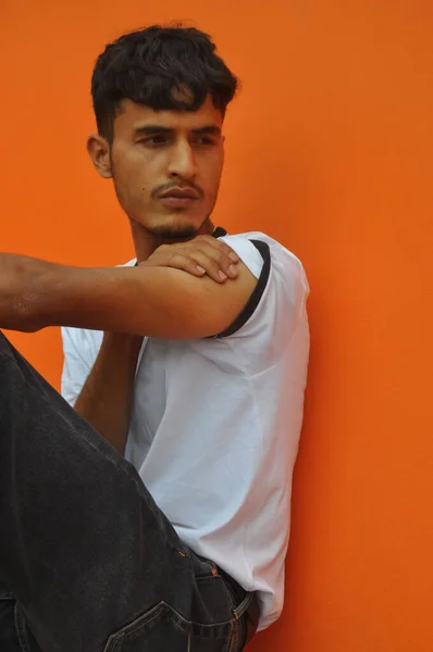 Side View Handsome Indian Guy Looking Sideways While Sitting Posing — Stok fotoğraf