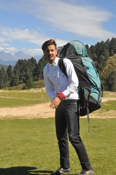 山の中でパラシュートのバックパックを運ぶとカメラを見て若い男の完全な長さ — ストック写真