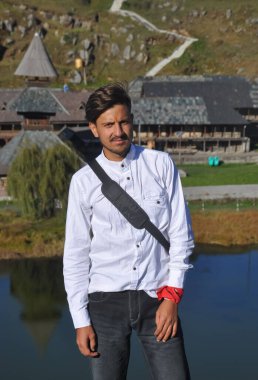 Mandi, Himachal Pradesh 'teki Parashar Rishi tapınağında kameraya bakan Hintli bir gencin ön görüntüsü. 