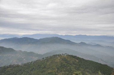 Yağmurdan sonra bulutlu havada sisle kaplı güzel dağ katmanları